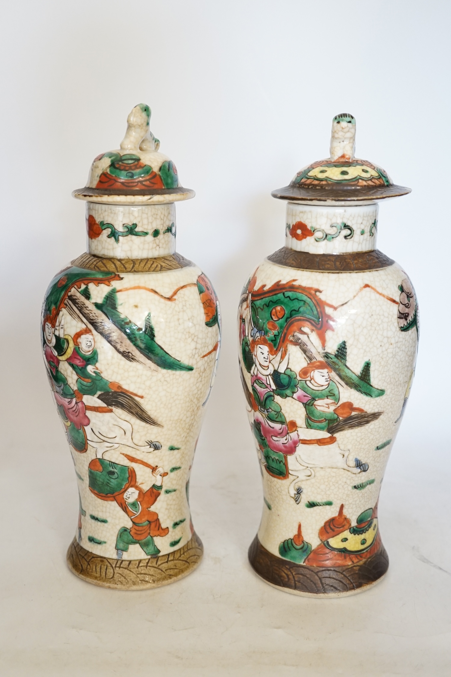 A pair of 19th century Chinese famille rose crackle glaze vases and covers, 31cm. Condition - fair to good